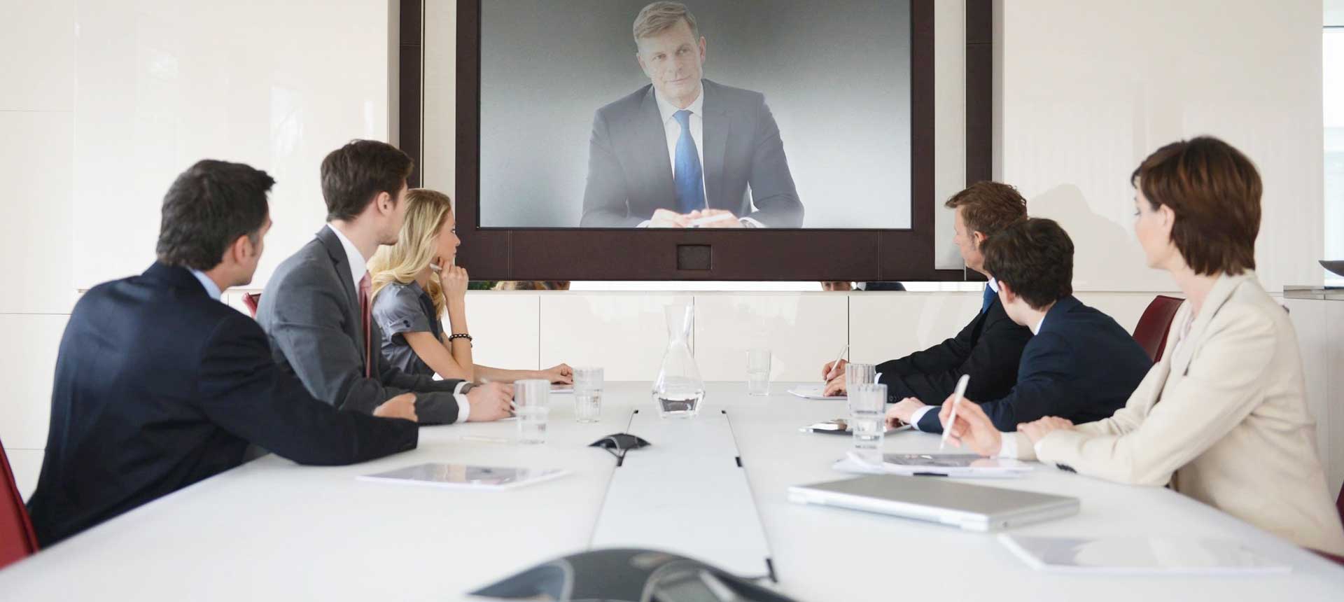 Business people sitting on conference room having a video call